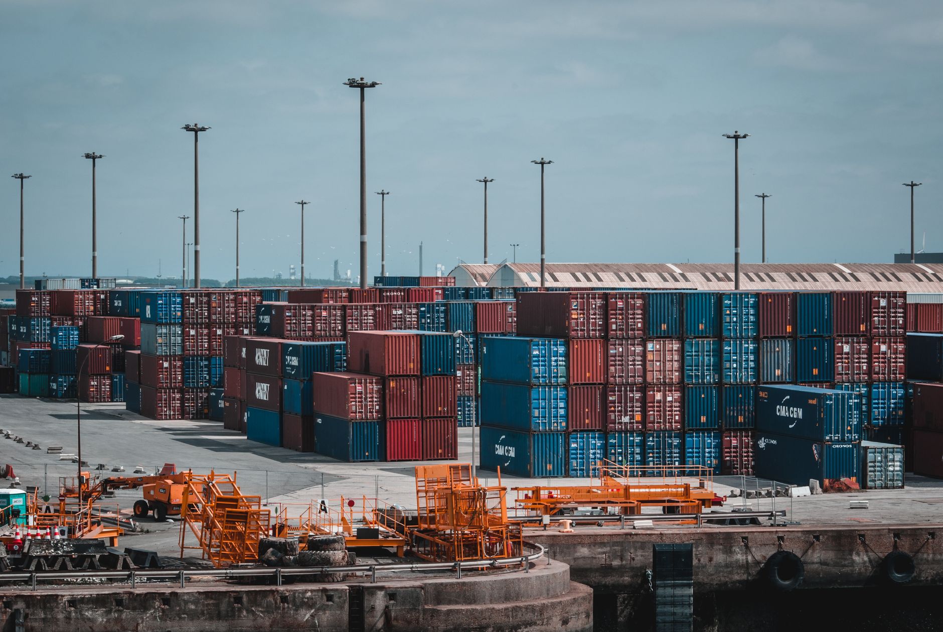 Contentores empilhados num terminal portuário